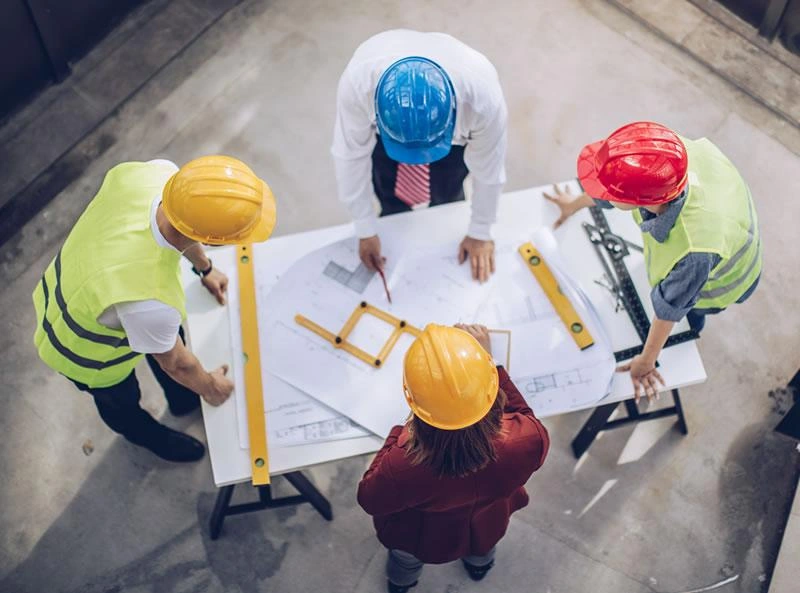 Profesionales de ingeniería revisando planos de un proyecto